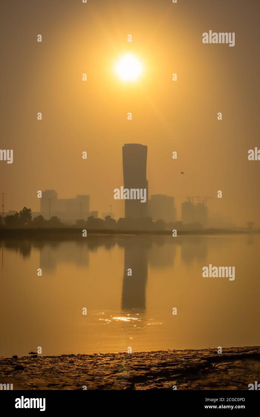 Sunrise Sky vista sfondo dietro la torre della porta capitale di Abu Dhabi, grattacieli nella capitale degli Emirati Arabi Uniti Foto Stock