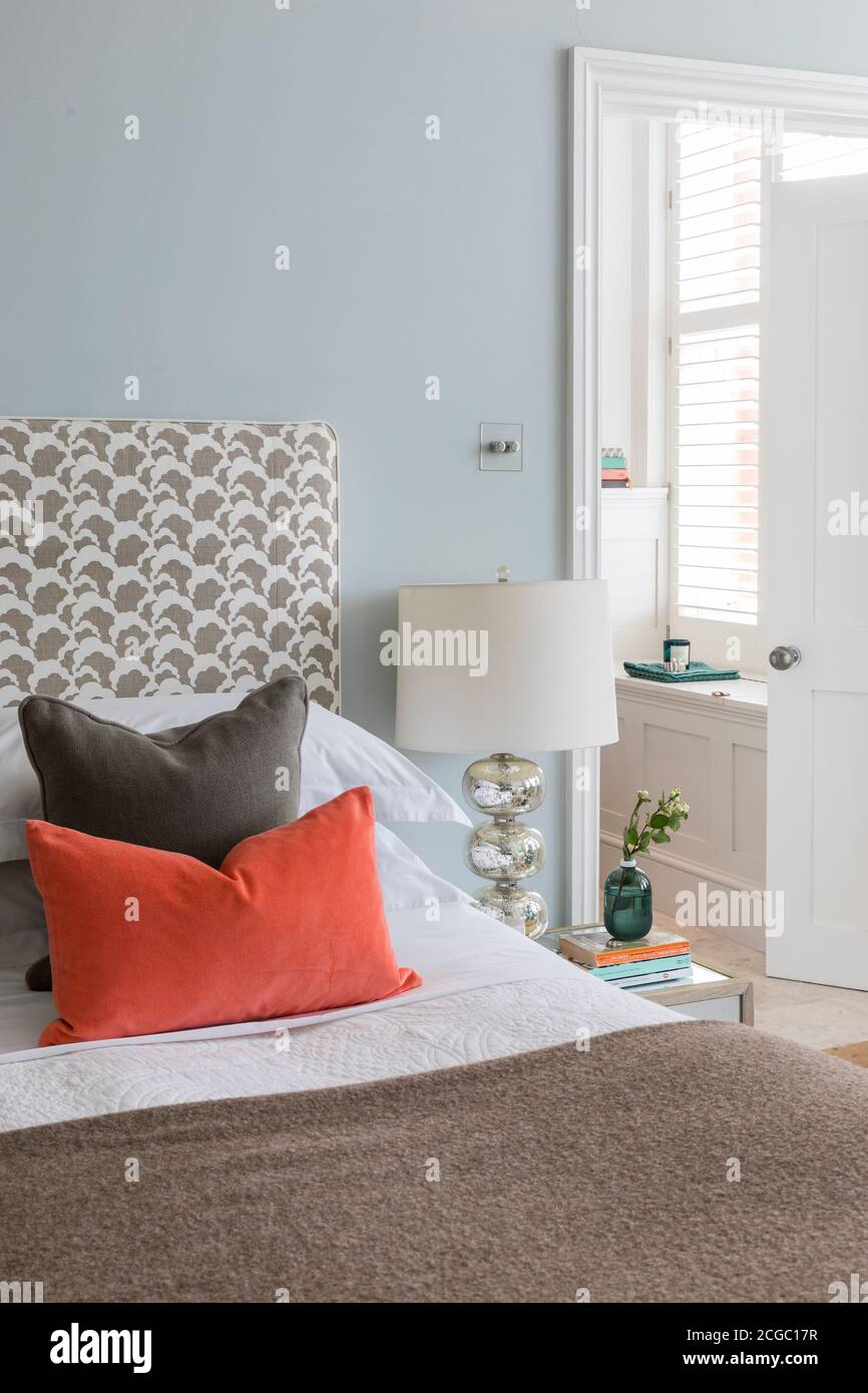 Cuscini su un letto in un appartamento ristrutturato a Hove, East Sussex, UK. Foto Stock