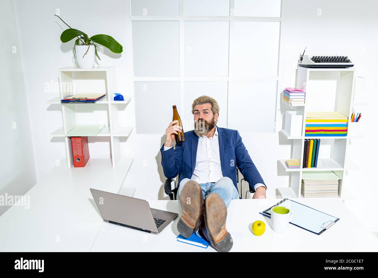 Uomo ubriaco alla fine della giornata lavorativa. Uomo d'affari ubriaco in ufficio. Concetto di alcolismo. Foto Stock