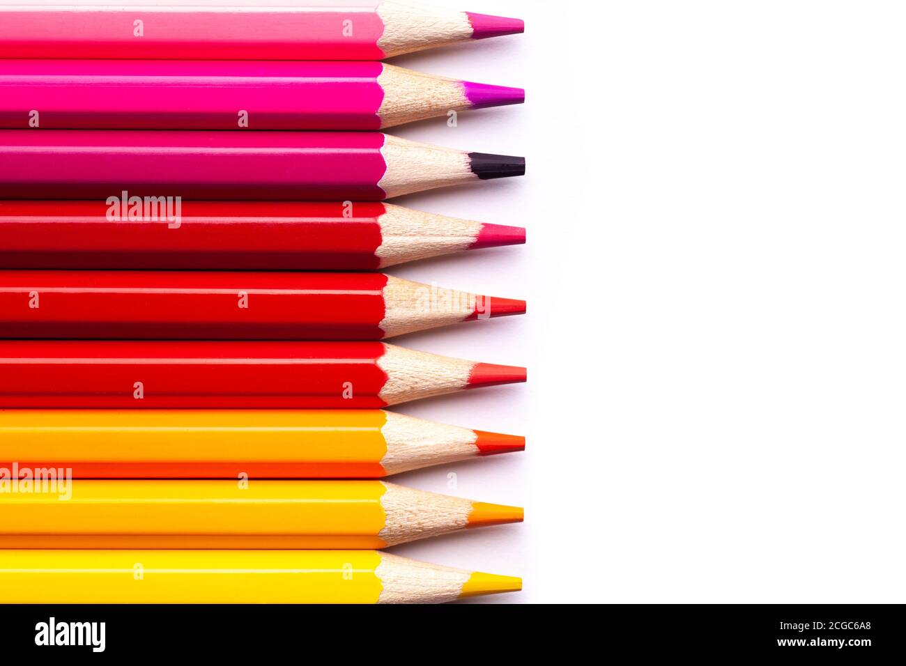 matite di legno multicolore in tonalità rosse su sfondo bianco isolato, mock up, orizzontalmente Foto Stock