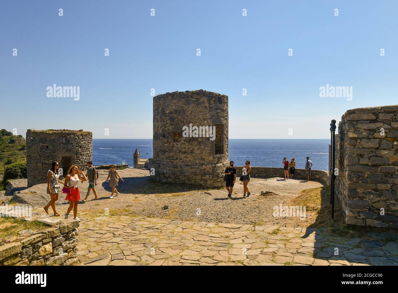 Due torri cilindriche un tempo utilizzate come torri di osservazione e più tardi come mulini a vento nel vecchio villaggio di pescatori con turisti, Porto Venere, la Spezia, Italia Foto Stock