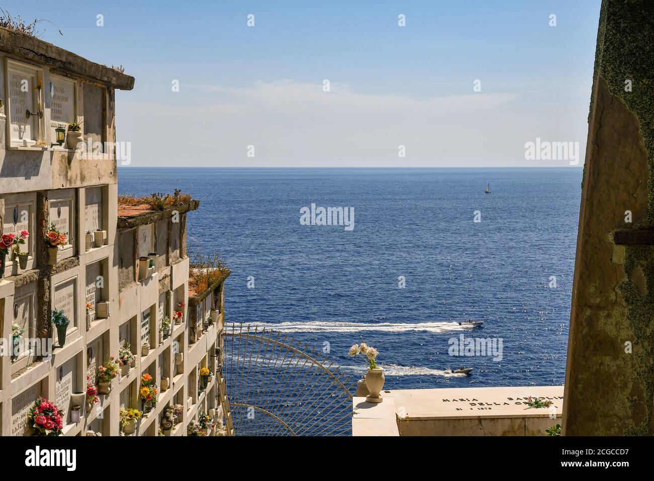 Nicchie nel cimitero che si affaccia sul mare con barche di passaggio in estate, Porto Venere, la Spezia, Liguria, Italia Foto Stock