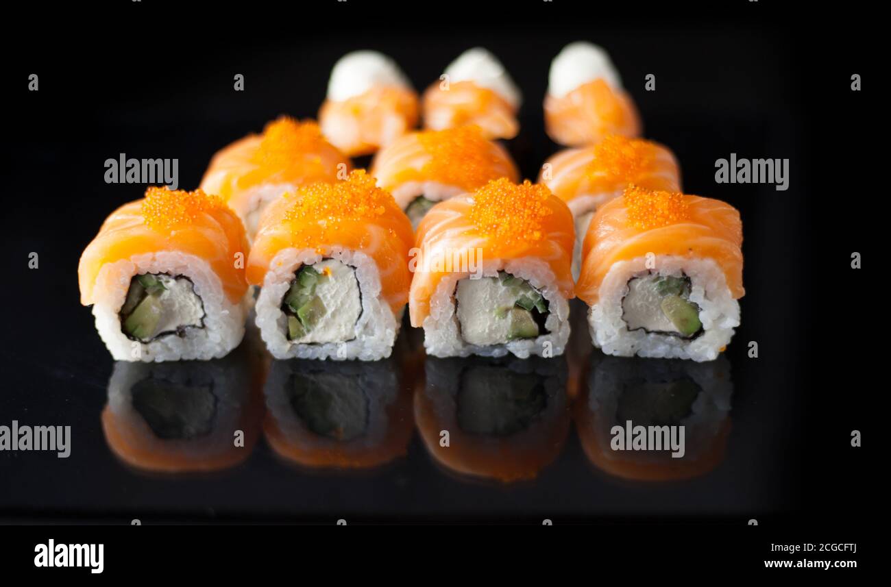 Set di sushi al salmone. Sushi roll Philadelphia con pesce rosso, salmone, caviale rosso. Arrotolare con avocado morbido e formaggio cremoso sotto uno strato di caviale massago Foto Stock