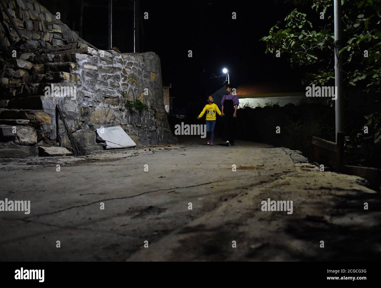 (200910) -- LINGCHUAN, 10 settembre 2020 (Xinhua) -- Chen Yanzi cammina il terzo anno studente fu Zhenzhen casa di notte nel villaggio di Mawuzhai di Gujiao Township della contea di Lingchuan, Jincheng City, la provincia di Shanxi della Cina settentrionale, 8 settembre 2020. Situata nelle profondità dei monti Taihang, a più di 1,300 metri sul livello del mare, la scuola elementare di Mawuzhai, con i suoi sei studenti, è l'unica scuola nel raggio di decine di chilometri. Chen Yanzi, all'età di 25 anni, è venuto qui nel settembre 2019 ed è diventato un insegnante. Chen Yanzi proveniva dal centro di Jincheng e ci vollero più di t. Foto Stock