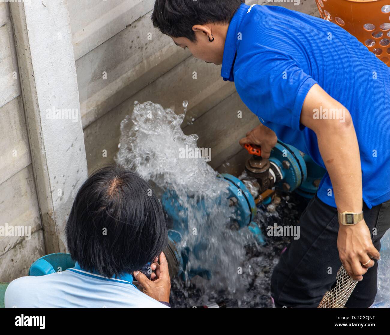 SAMUT PRAKAN, THAILANDIA, 15 2020 GIUGNO, la manutenzione dei tubi dell'acqua. Un team di addetti alla manutenzione lavora su un tubo dell'acqua da cui scorre il flusso d'acqua. Foto Stock