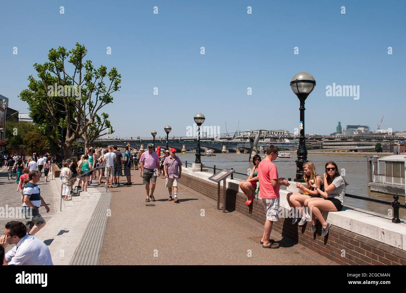 I turisti camminano lungo la South Bank del Tamigi a Londra, Inghilterra. Foto Stock