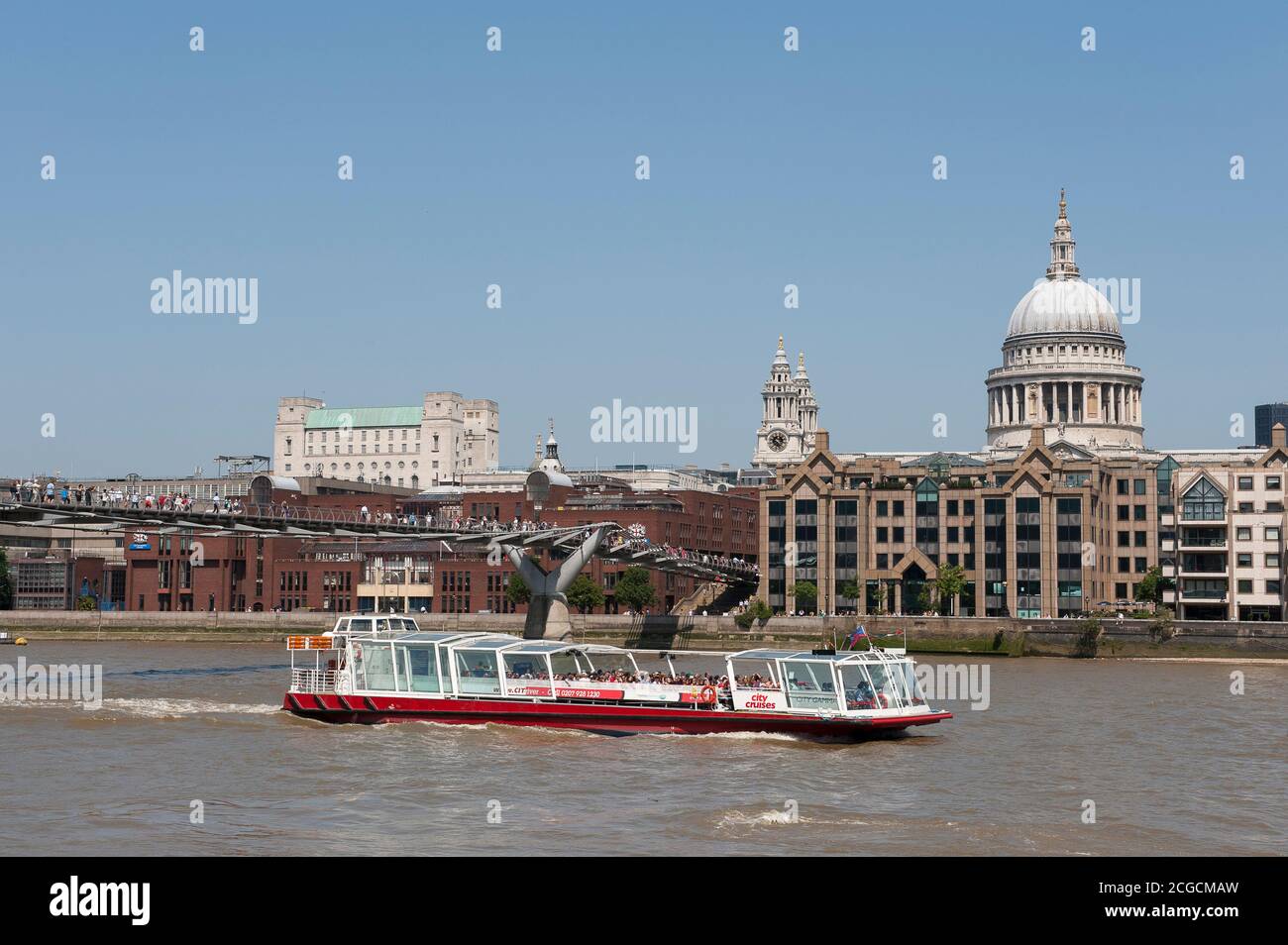La città naviga in barca passando sotto il Millennium Bridge sul Tamigi con la cattedrale di St Paul sullo sfondo, City of London, Inghilterra. Foto Stock