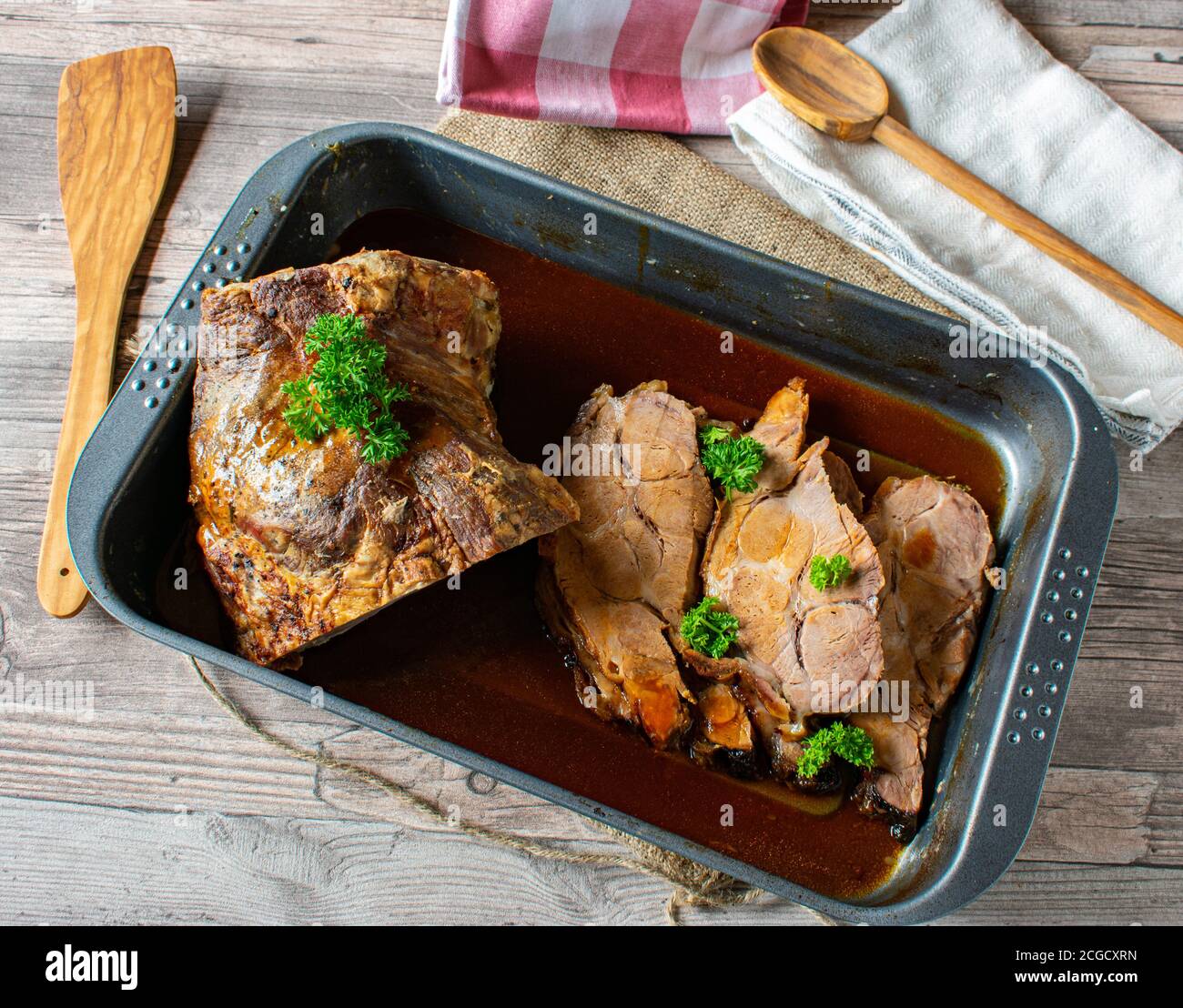Carne di maiale arrosto tagliata a fette con sugo di carne in una teglia da forno Foto Stock