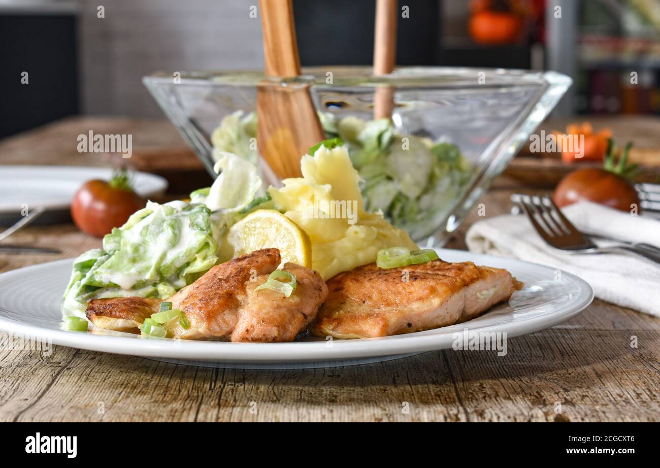 pesce fritto con purè di patate e insalata - ricetta tedesca servito su un piatto bianco Foto Stock