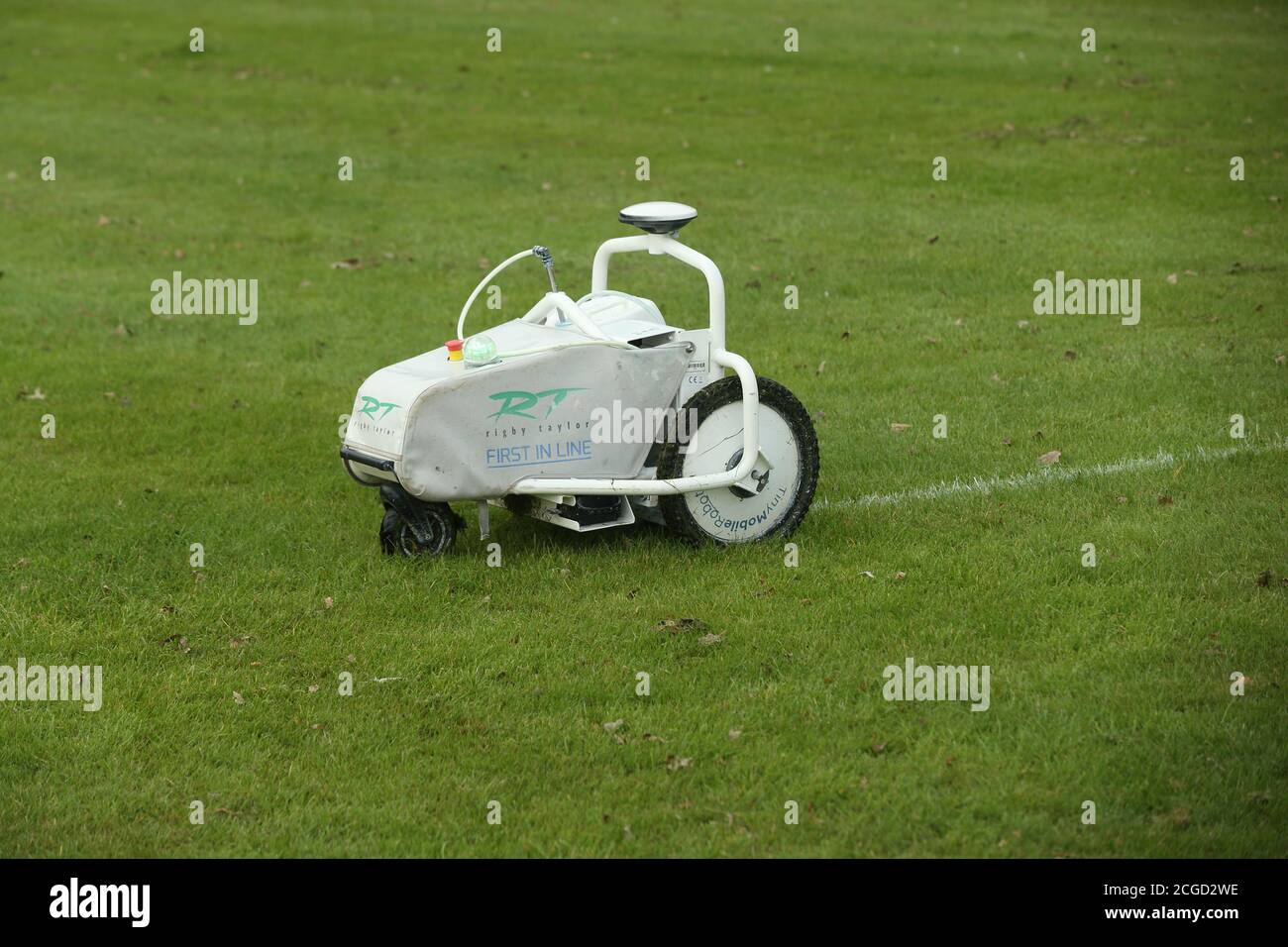 Macchina automatica robotica per la verniciatura di linee bianche che opera su erba in un campo sportivo Foto Stock