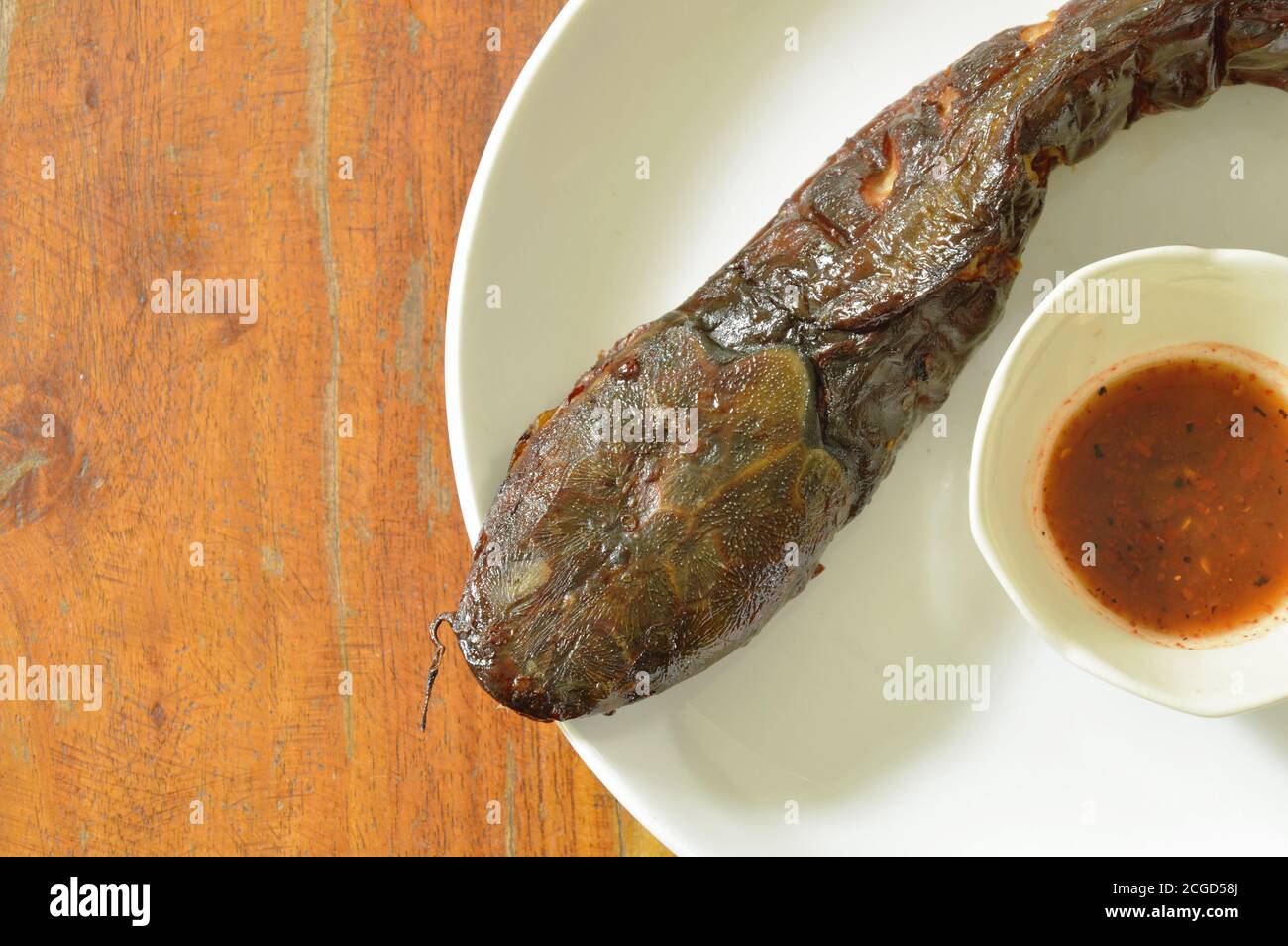 immersione di pesce gatto alla griglia con salsa piccante su piatto Foto Stock