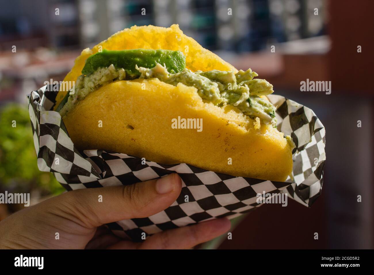 Qualcuno che mangia arepa in una giornata di sole Foto Stock