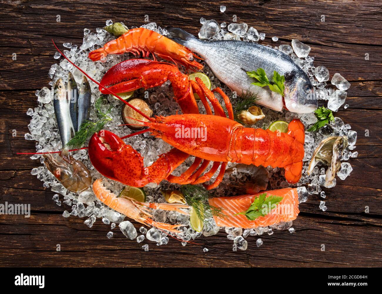 Pesce fresco, aragosta, granchio, cozze, gamberi, pesce, granchio, bistecca di salmone, pesce orata e altri conchiglie serviti su vecchio tavolo di legno Foto Stock