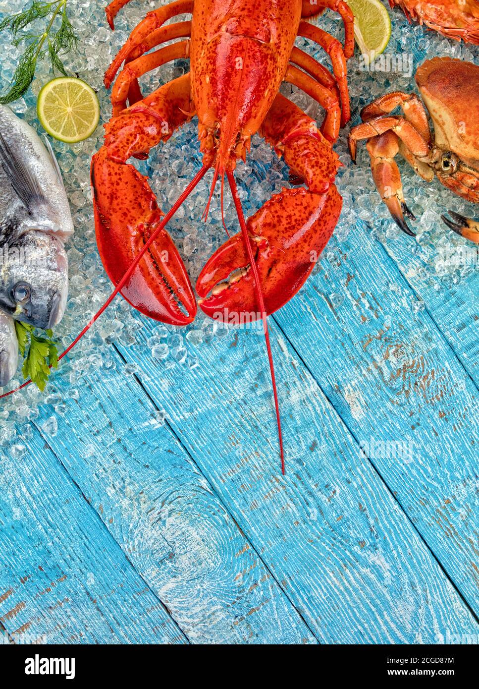 Aragosta intera con frutti di mare, granchio, cozze, gamberi, pesce, bistecca di salmone servita su ghiaccio tritato e tavolo di legno Foto Stock