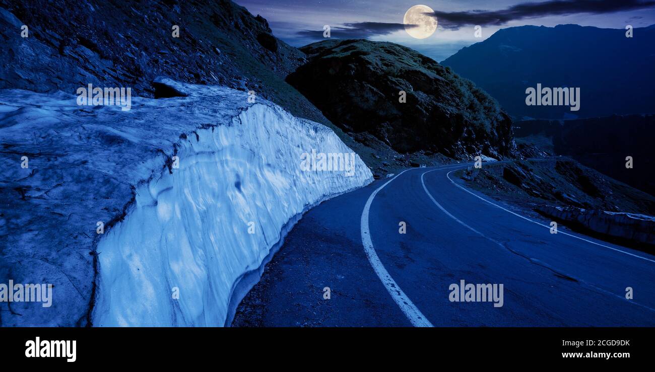 strada di montagna nella dorsale di fagaras di notte. meta di viaggio popolare in piena luce luna. ampia serpentina. panorama estivo del mattino Foto Stock