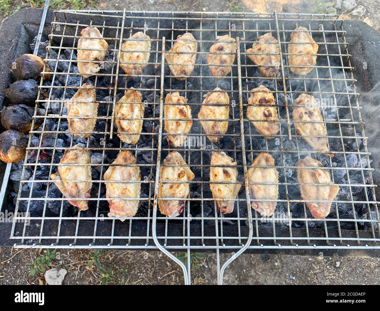 Delizioso pollo grigliato al barbecue. Ali di pollo sul mangal in natura. Picnic. Primo piano. Foto Stock