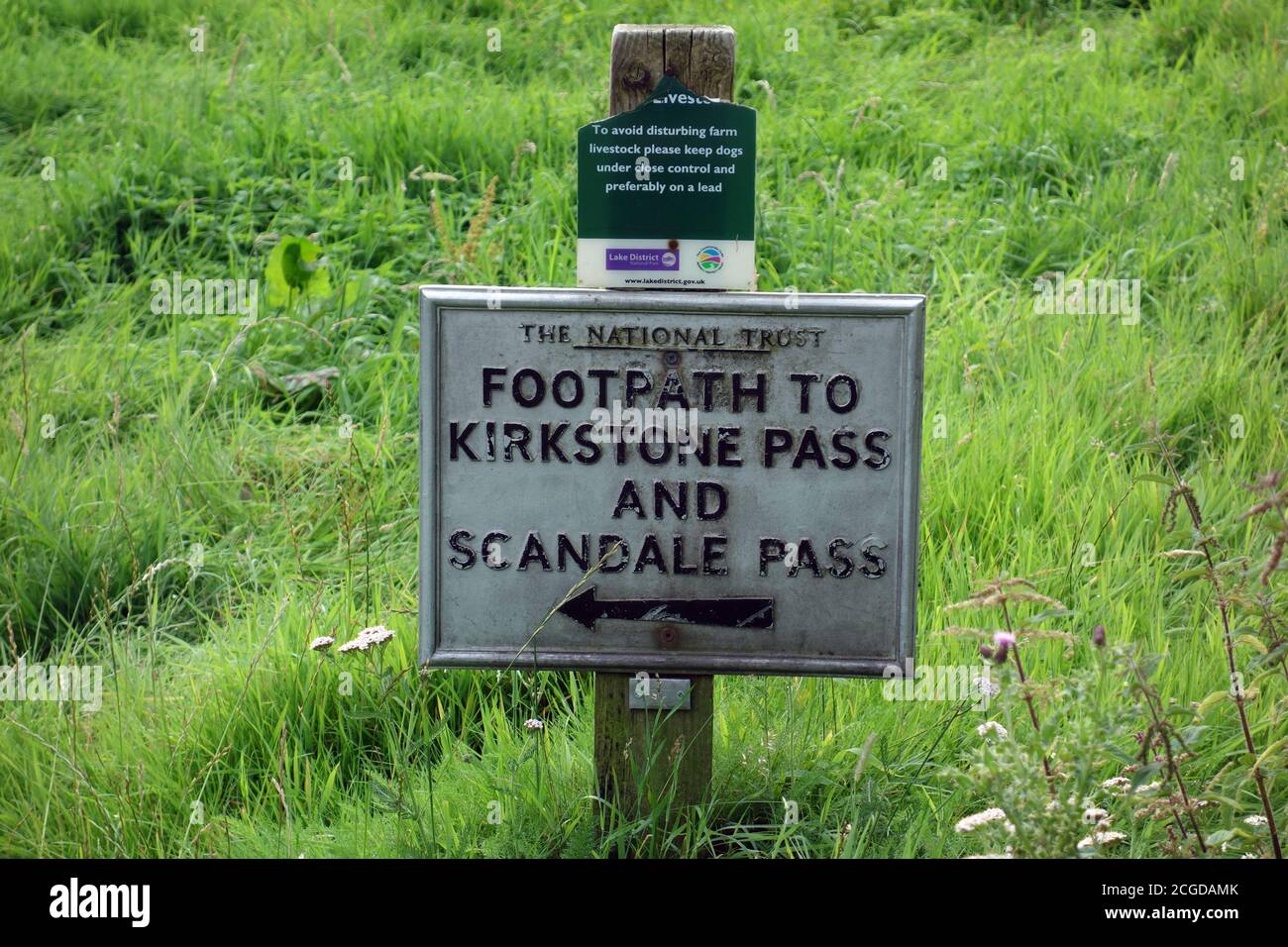 Metal Sign on Wooden Post for the footpath to Kirkstone & Scandale Pass Near Brothers Water in the Lake District National Park, Cumbria, England, UK. Foto Stock