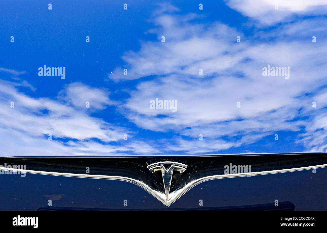 Berlino, Germania. 10 settembre 2020. Il logo Tesla su un'auto con le nuvole riflesse nel cofano alla presentazione di una stazione di ricarica Tesla di ultima generazione sul sito EUREF Campus Berlin. Come una delle prime sedi in Germania, verrà messa in funzione una nuova stazione di ricarica rapida Tesla per auto elettriche. Credit: Jens Kalaene/dpa-Zentralbild/dpa/Alamy Live News Foto Stock