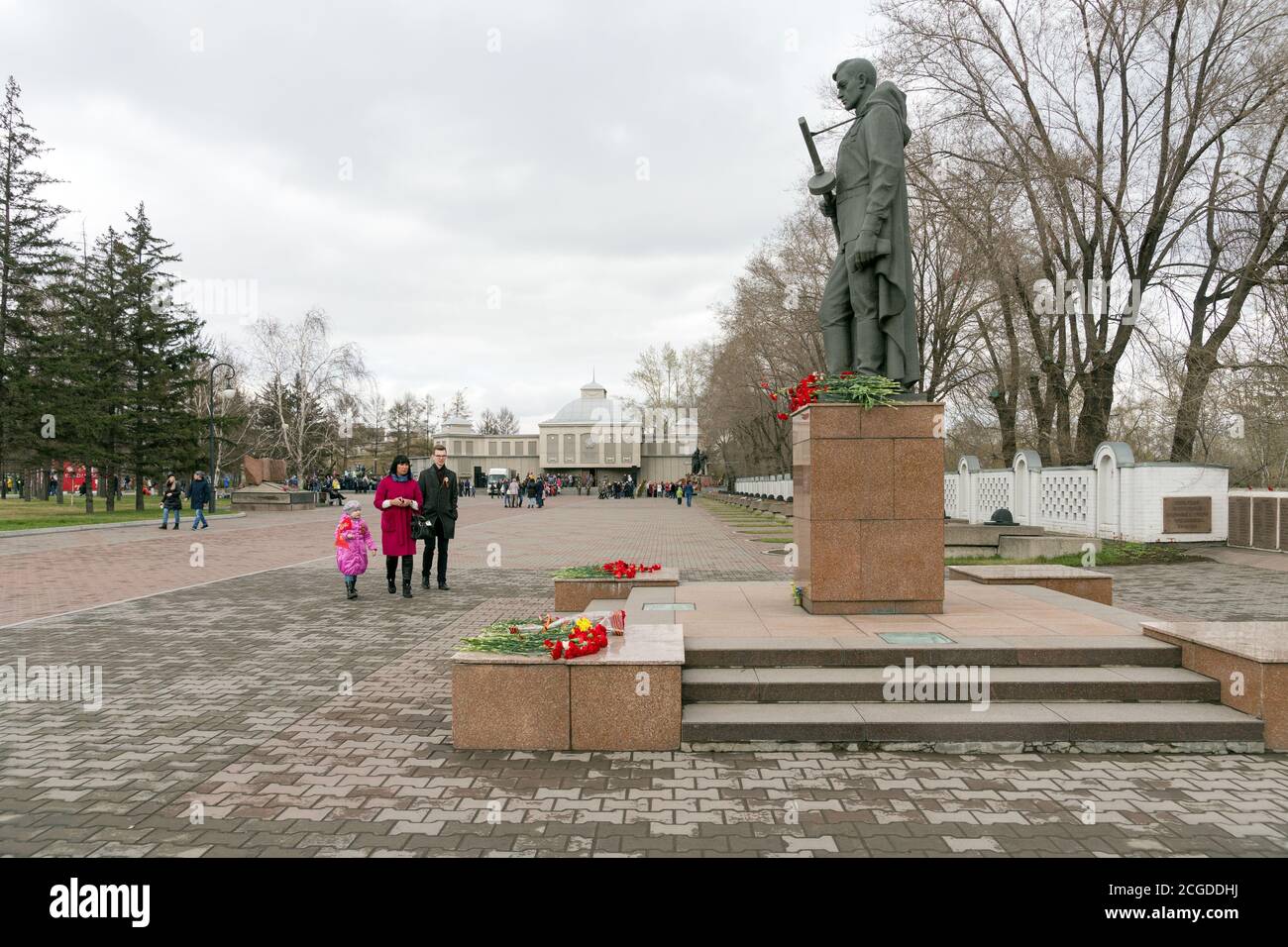 La gente va al monumento di Alesha ai soldati del La seconda guerra mondiale sullo sfondo del Memoriale della Vittoria nel Krasnoyarsk città Foto Stock