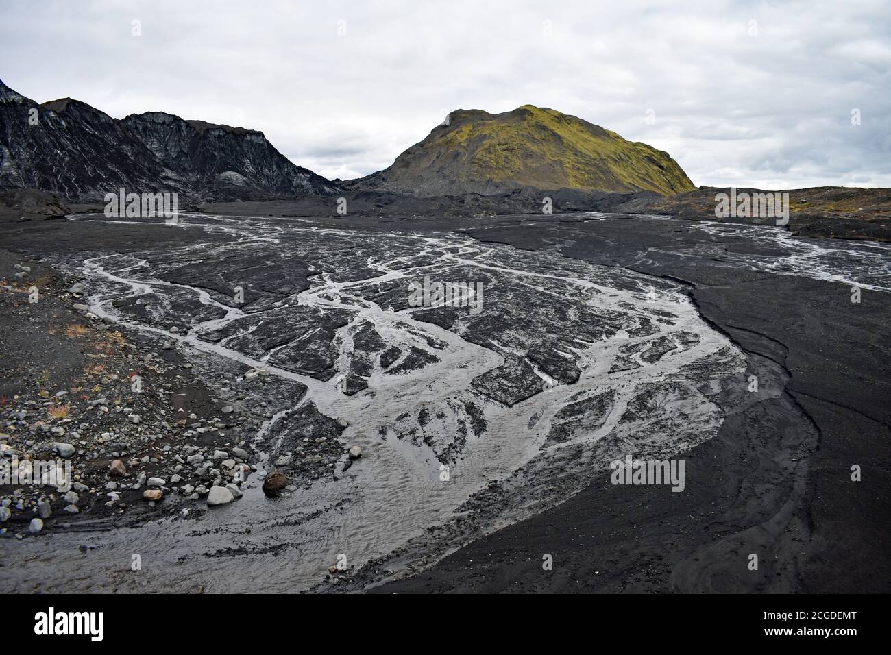 La sabbia vulcanica nera copriva il Ghiacciaio di Kotlujokull, un ghiacciaio di uscita di Myrdalsjokull. L'acqua di ghiaccio fusa crea un modello sulla sabbia. Islanda Foto Stock