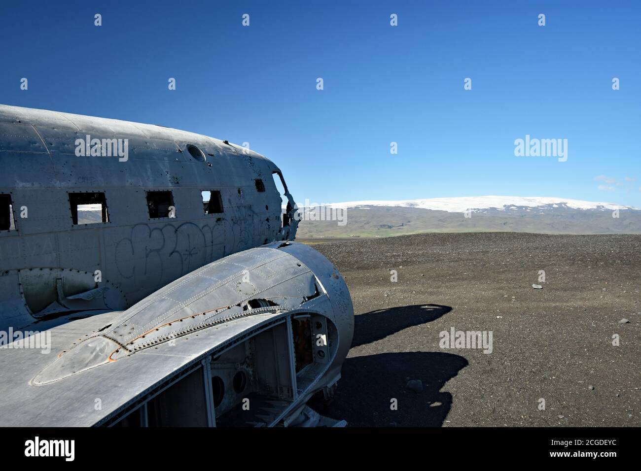 Guardando lungo il lato del Solheimasandur piano Wreck verso il cockpit. Myrdalsjokull si può vedere dominando il cielo blu profondo. Islanda del Sud. Foto Stock
