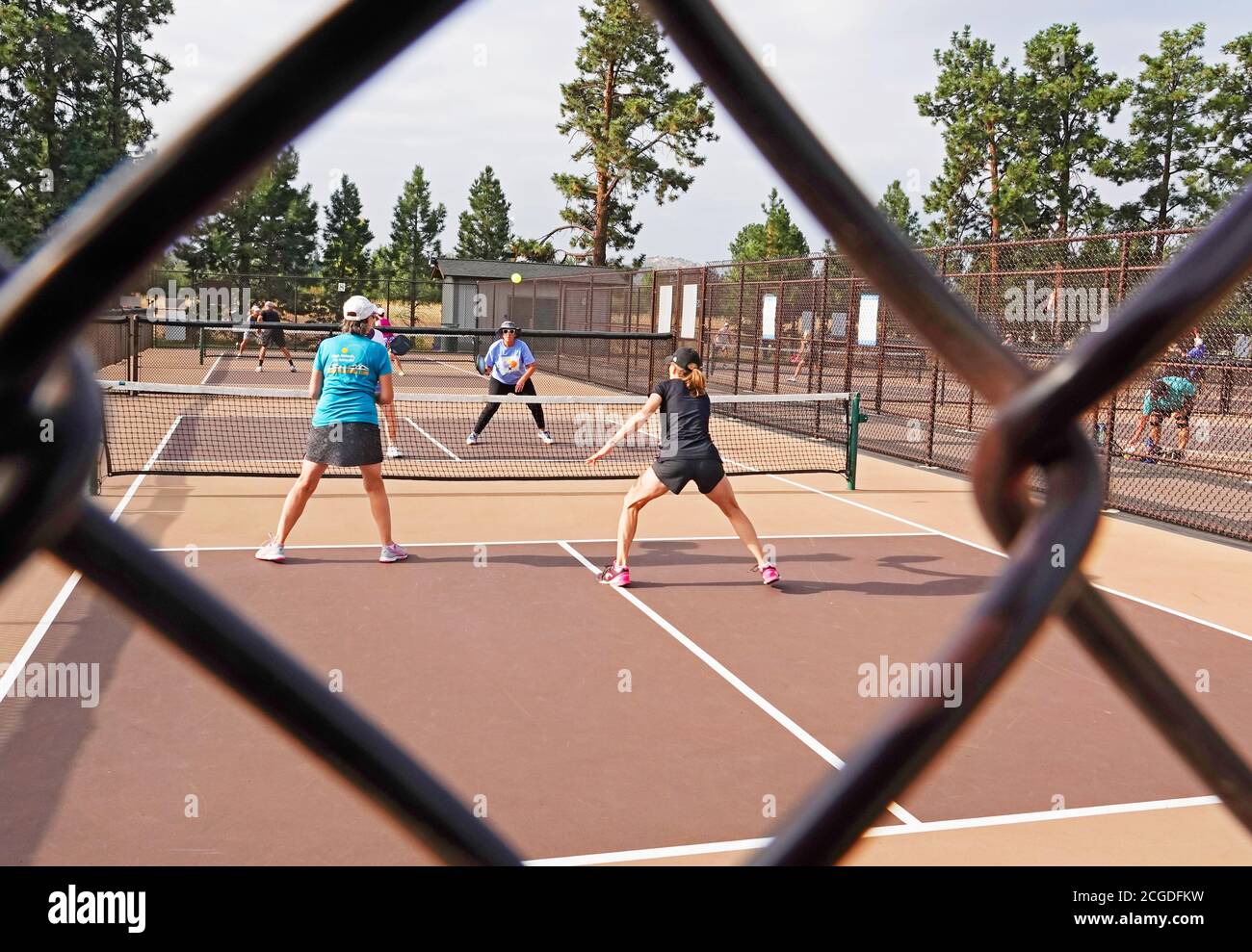 Donne di mezza età che giocano a pickleball su un campo da pickleball in un parco cittadino a Bend, Oregon Foto Stock