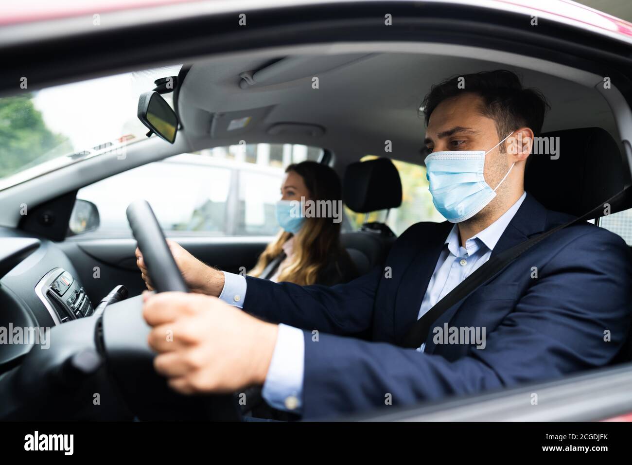 Condivisione di auto e carpooling di persone con maschere facciali Foto Stock