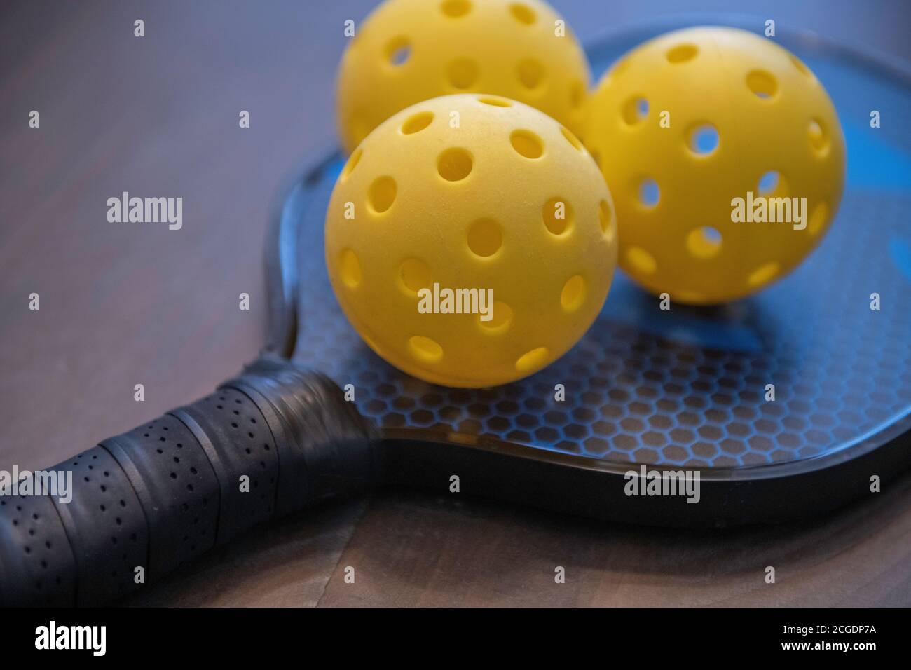 Pickleballs e una pagaia. Pickleball è diventato lo sport in più rapida crescita in America, giocato su un campo da tennis di 1/4 dimensioni. Foto Stock
