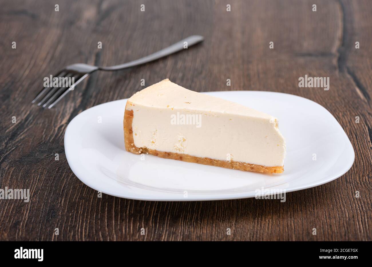 Fetta di cheesecake in stile newyorkese su un piatto bianco. Foto Stock