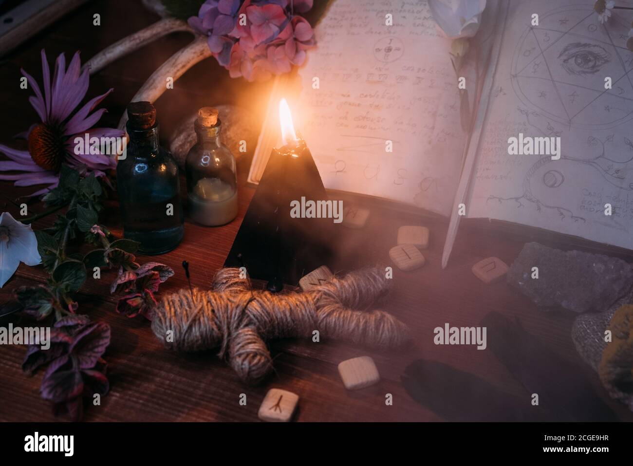 Apri il vecchio libro con incantesimi magici, rune, candela nera ed erbe sulla tavola delle streghe. Concetto occulto, esoterico, divinazione e wicca. Halloween vintage backg Foto Stock