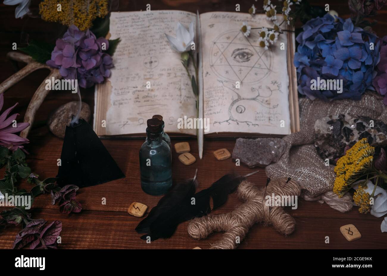 Apri il vecchio libro con incantesimi magici, rune, candela nera ed erbe sulla tavola delle streghe. Concetto occulto, esoterico, divinazione e wicca. Halloween vintage backg Foto Stock