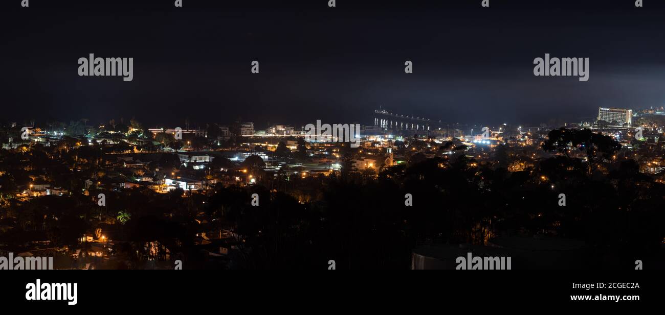 Vista panoramica della città costiera di Ventura accoccolata contro L'Oceano Pacifico di notte con le lampade della città che brillano con una foschia che si avvolgono Foto Stock