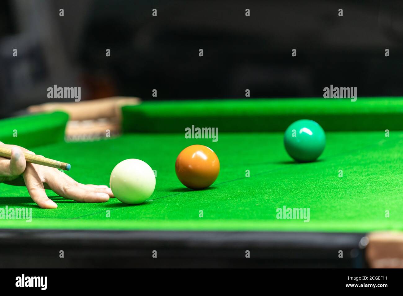 Un uomo che gioca a snooker al bar. Giocatore di snooker che punta la palla di snooker sul tavolo di snooker. Foto Stock