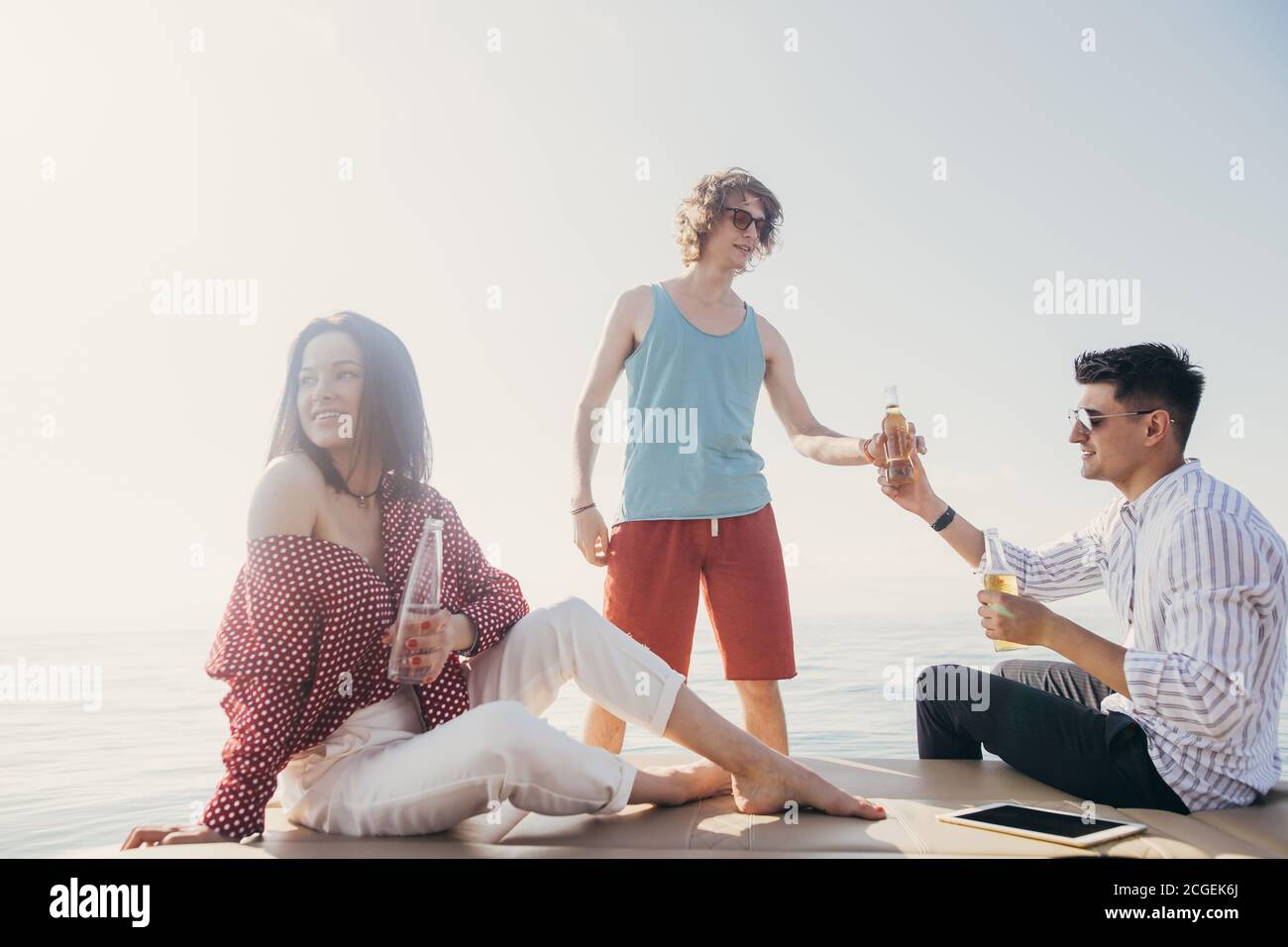 Gli amici a bere birre in battello partito. Gruppo di persone sulla festa yacht Foto Stock