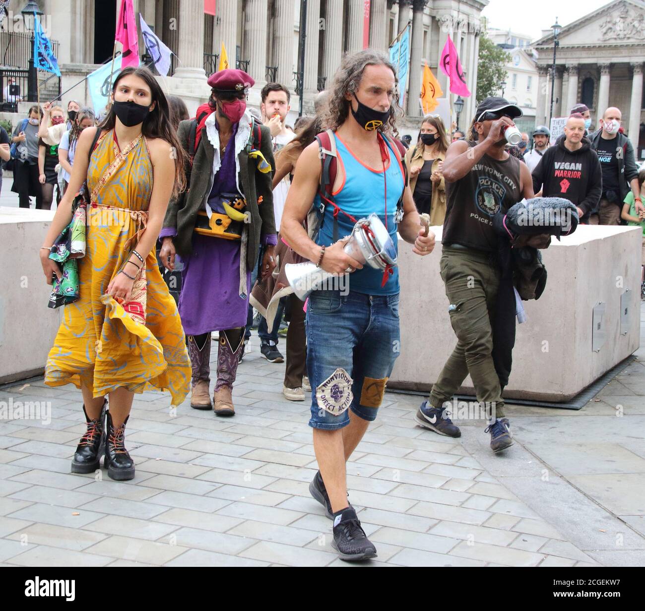 I manifestanti che indossano maschere si fanno strada attraverso Trafalgar Square.i dimostranti della ribellione estinzione si recano a Westminster come parte del giorno di protesta contro l'ingiustizia, opponendosi alle numerose ingiustizie umane, animali e ambientali del settore della moda. Foto Stock