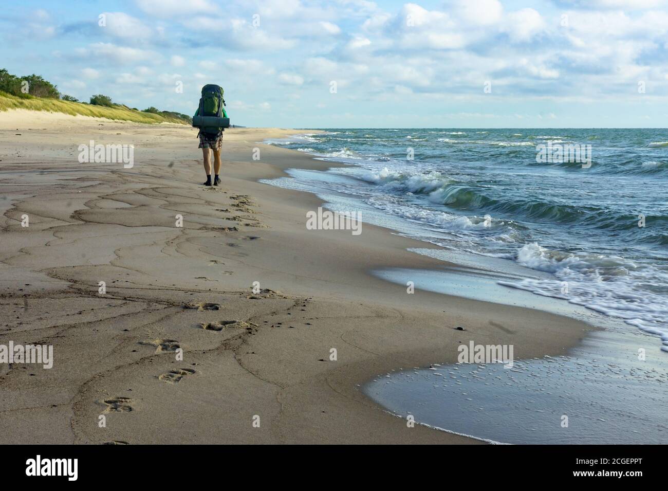 Un uomo con un grande zaino, una passeggiata turistica lungo la costa del mare, Mar Baltico, Russia, regione di Kaliningrad, 3 luglio 2020 Foto Stock