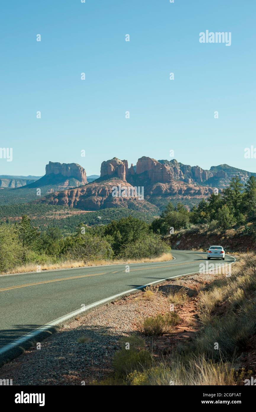 Un'auto sulla Red Rock Loop Road con Cathedral Mountain sullo sfondo a Sedona, Arizona, Stati Uniti. Foto Stock