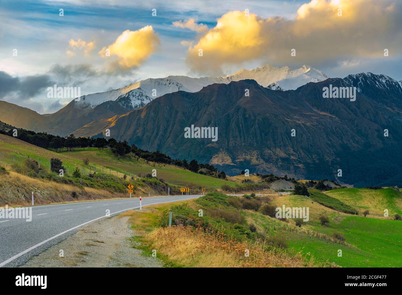 Vista sulle montagne e sulla strada a Wanaka Otago, NewZealand, quando il sole tramonta. C'era una bella nuvola gialla. Foto Stock