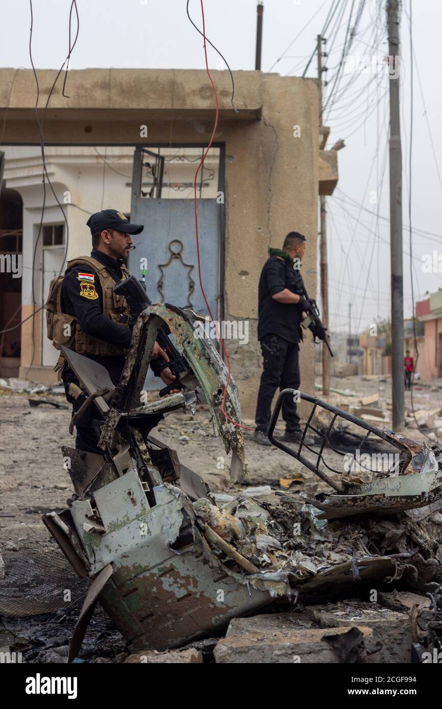 Due membri delle forze speciali irachene sorvegliano un punto di distribuzione alimentare nel distretto di al Bakir a East Mosul, Iraq. Foto Stock