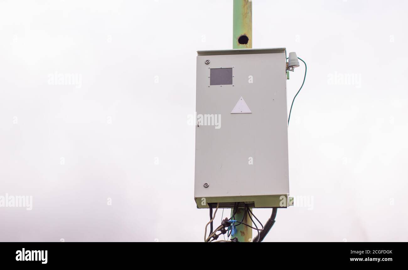 Scatola elettrica bianca su un palo all'esterno della casa. Foto Stock