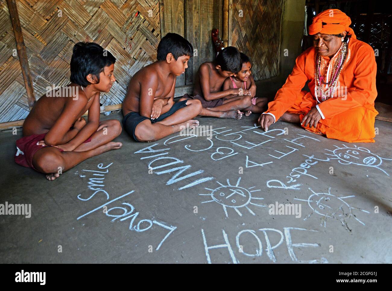 Il devoto sta insegnando ai bambini poveri del villaggio per il loro futuro nel villaggio remoto dell'India. Foto Stock