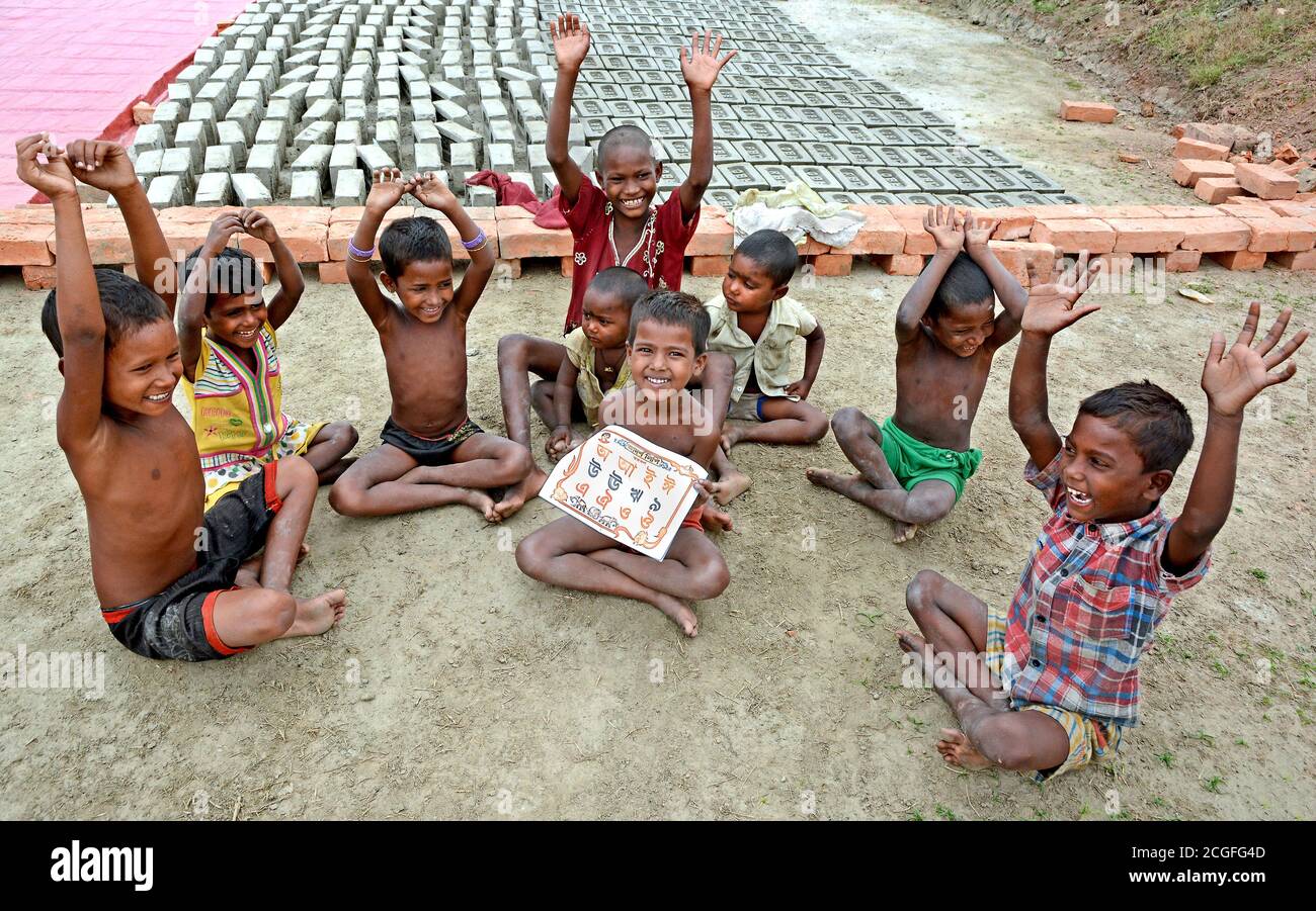 Il remoto villaggio di bambini lavoratori di mattoni sono felici di studiare libri per la conoscenza del loro futuro al Bengala Occidentale in India. Foto Stock