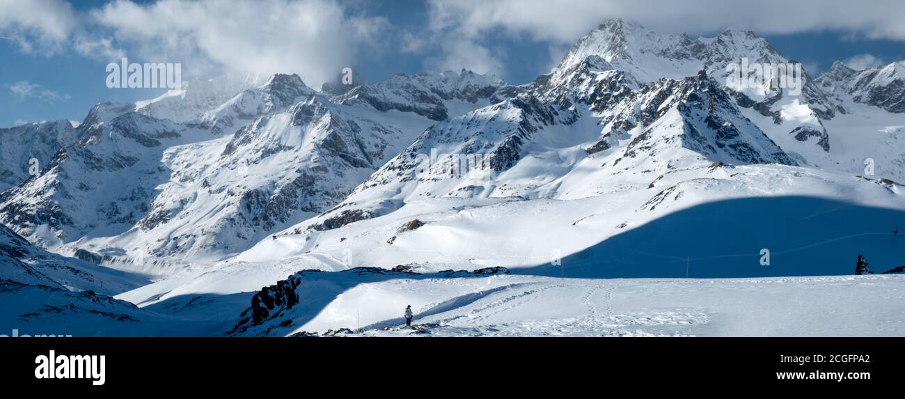 Zermatt, Svizzera - Feb 19 2020: Bandiera panoramica delle montagne svizzere in inverno con un solo amante della natura. Foto Stock