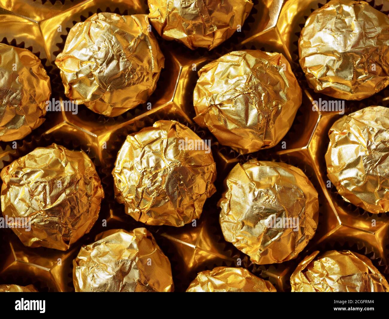 Caramelle di cioccolato in un involucro d'oro, caramelle di cioccolato  dolce. La vista dall'alto Foto stock - Alamy