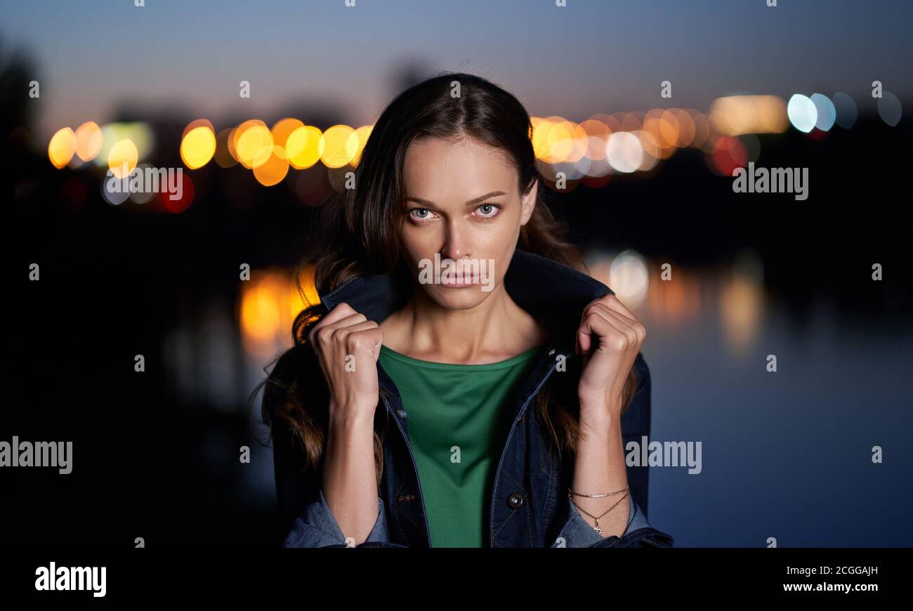 Ritratto di una bella donna. Notte città luci sullo sfondo. Foto Stock