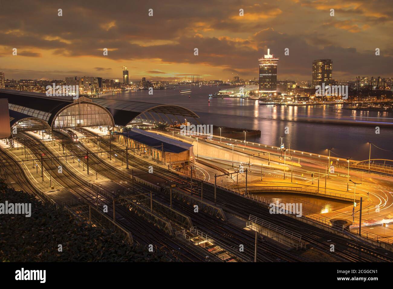 Tramonto sulla stazione ferroviaria di Amsterdam e sul fiume Amstel, Neterlands Foto Stock