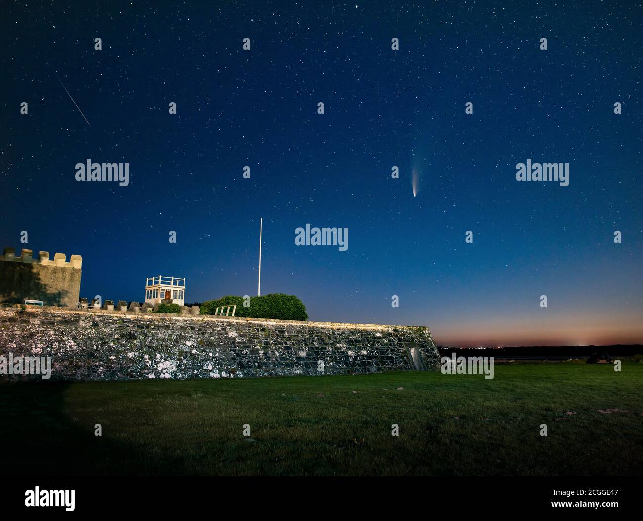 Cometa Neoswise su Fort Belan, Galles del Nord, Regno Unito con la stella di tiro a fianco sulla sinistra. Foto Stock