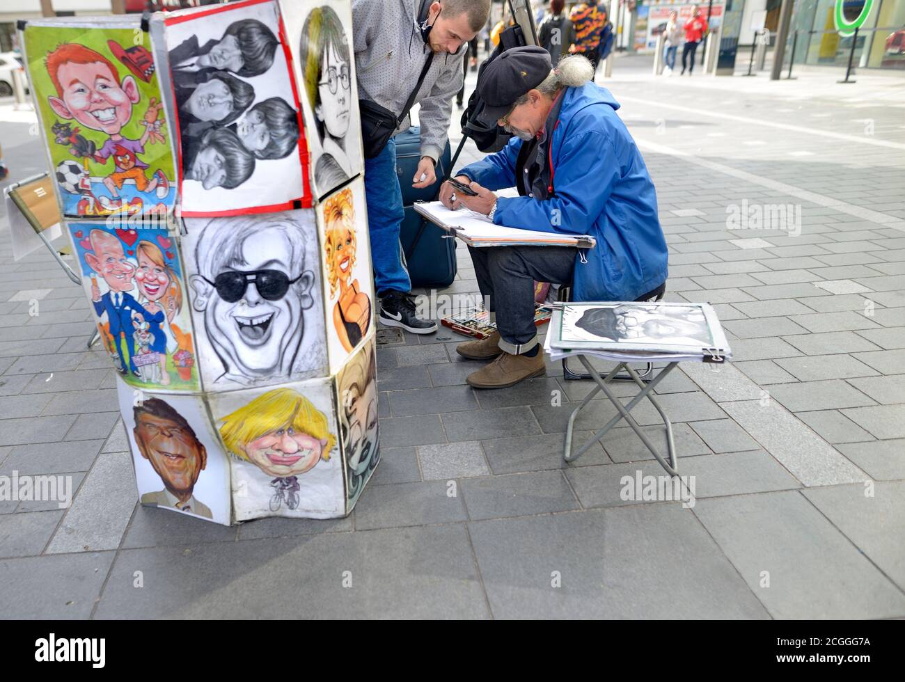 Londra, Inghilterra, Regno Unito. Artisti di strada disegnano le caricature in Leicester Square Foto Stock