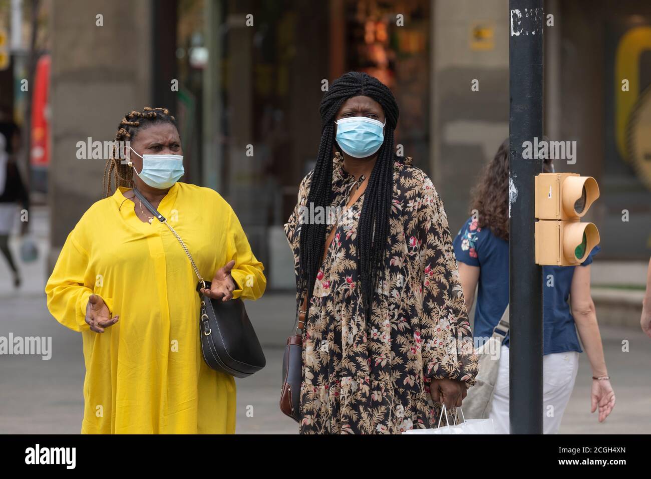 Saragozza, Spagna - 18 agosto 2020: Coppia di donne immigrate nere che parlano con maschere facciali, a causa della pandemia del coronavirus, nella zona centrale di Za Foto Stock