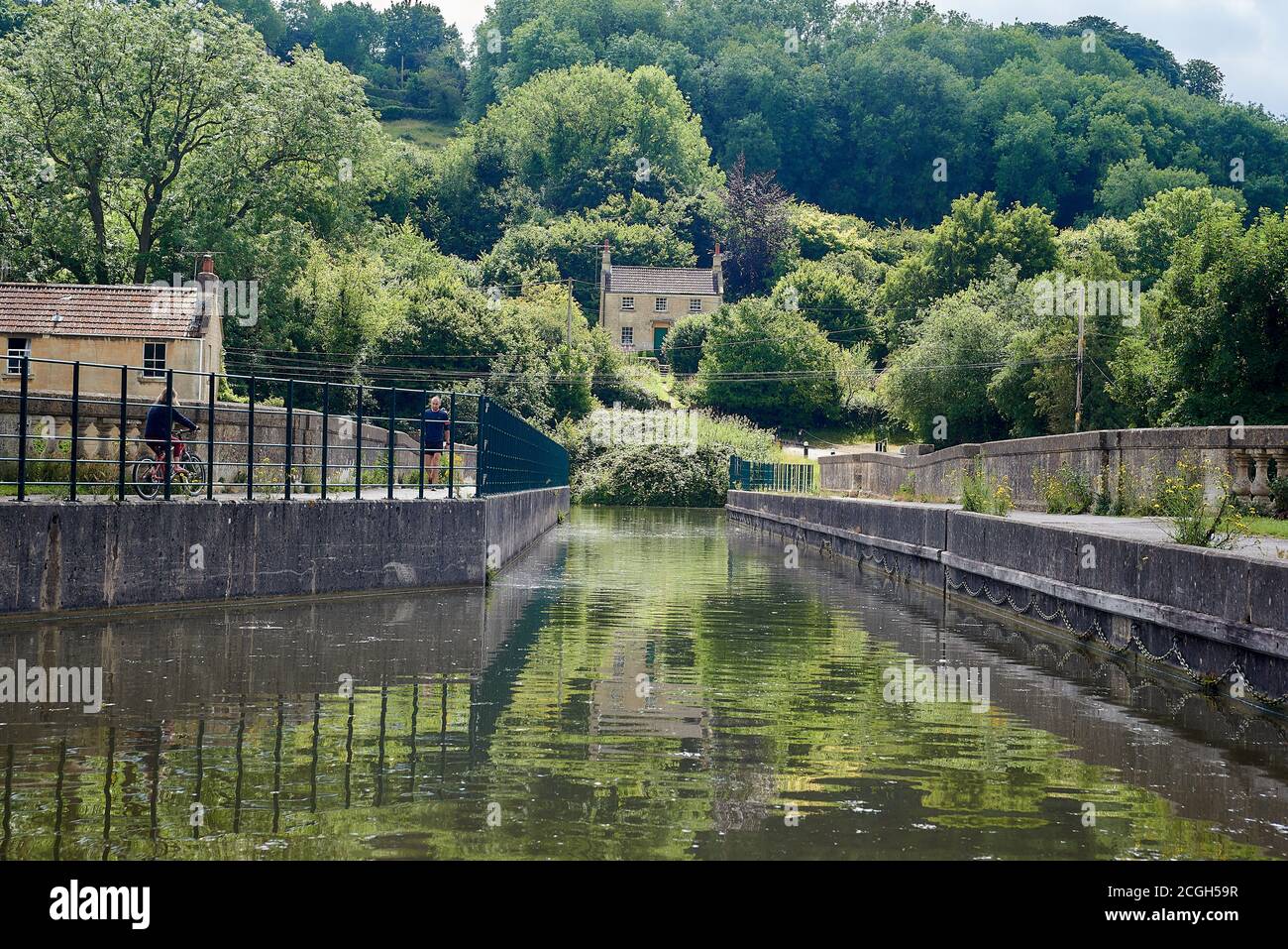 Lo storico acquedotto di Avoncliff sul canale Kennet e Avon nel Somerset, Inghilterra sud-occidentale, con un ciclista che lo cavalcava e riflessi Foto Stock